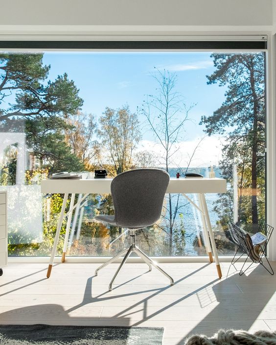Desk setup by a window with a view of blue sky and trees
