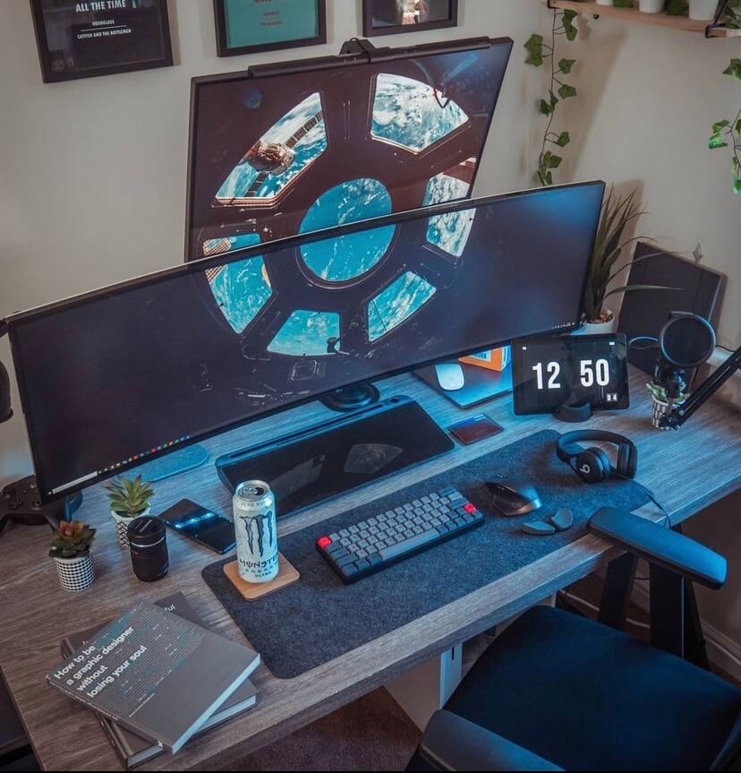 Desk setup with a midnight black notera wedge located underneath a large dual monitor.