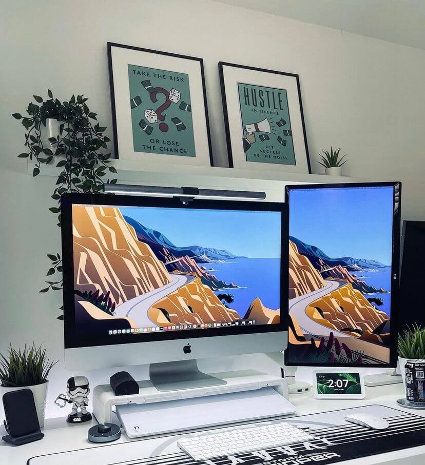 Desk setup with a brilliant white notera wedge located underneath a  dual monitor.